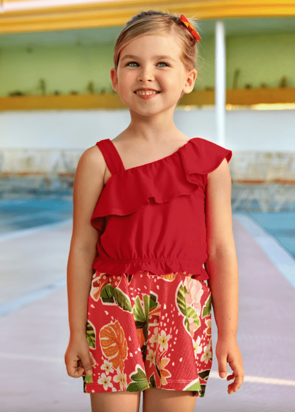 fille portant un ensemble rouge top asymétrique à volants et un short tropical