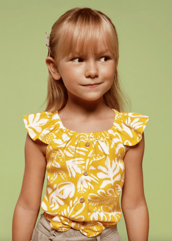 Fille portant le top imprimé fleurs tropical avec noeud couleur jaune